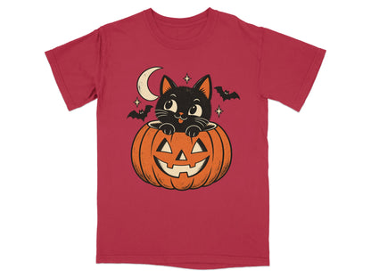 Black cat peeking from jack-o'-lantern with moon and bats on red t-shirt.