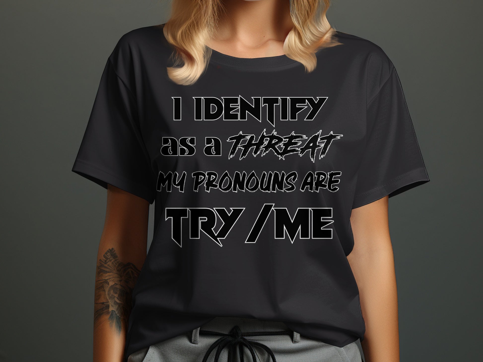 Black t-shirt on a woman with text "I IDENTIFY AS A THREAT MY PRONOUNS ARE TRY / ME".