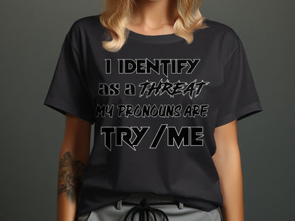 Black t-shirt on a woman with text "I IDENTIFY AS A THREAT MY PRONOUNS ARE TRY / ME".