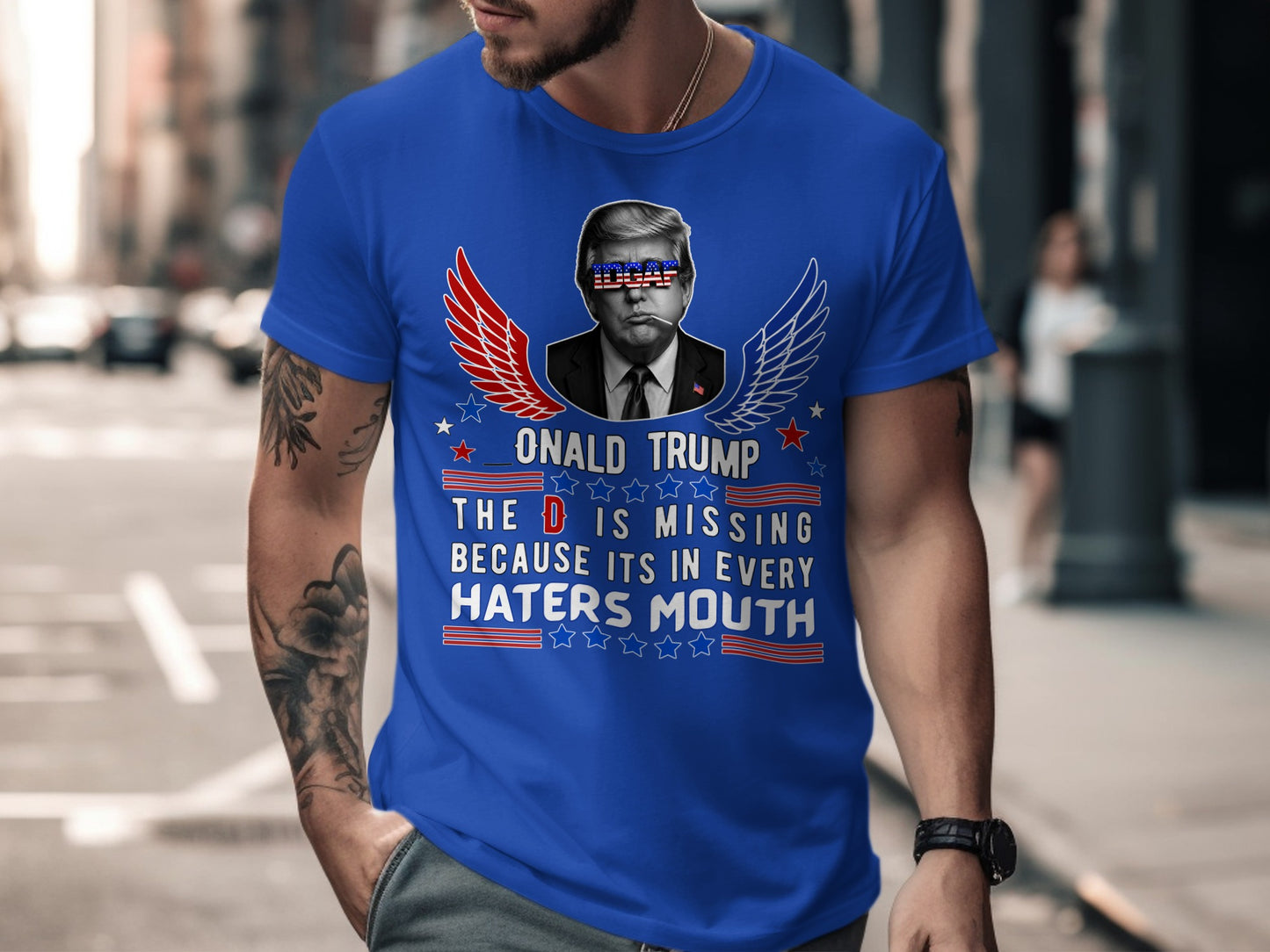 Blue t-shirt with Donald Trump graphic and text "The D is missing because its in every haters mouth".