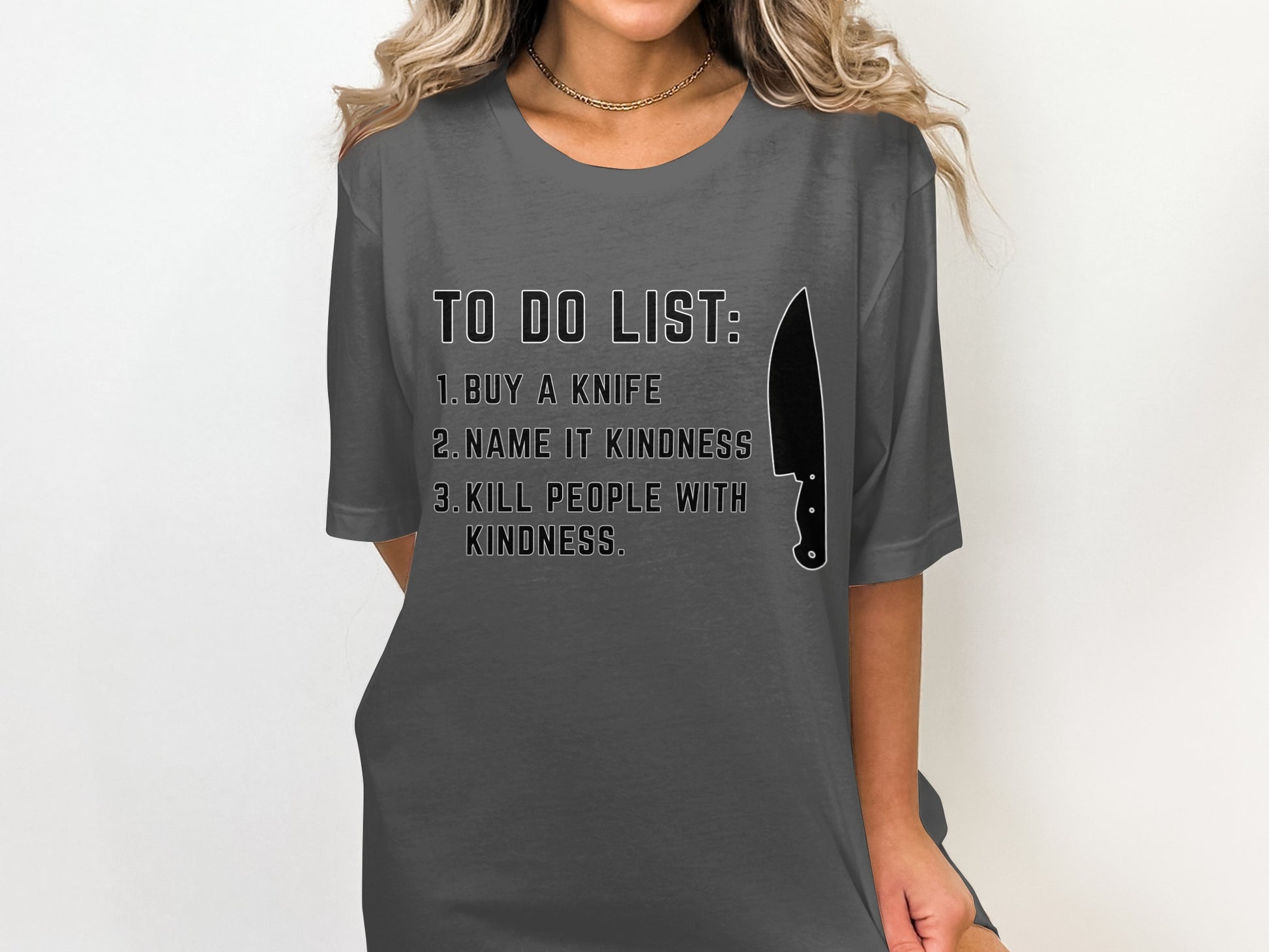Dark gray t-shirt with black text "TO DO LIST: 1. BUY A KNIFE 2. NAME IT KINDNESS 3. KILL PEOPLE WITH KINDNESS."