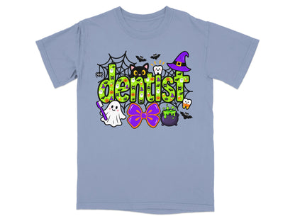 A periwinkle t-shirt features a colorful Halloween-themed graphic that spells the word dentist in green lettering.