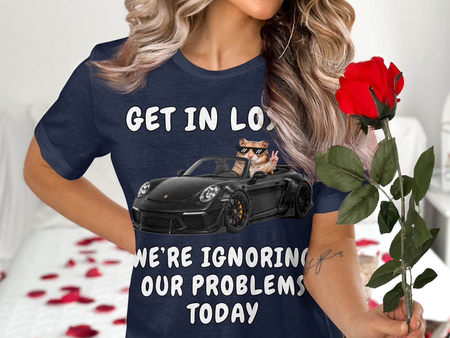 Dark blue t-shirt with white text: "GET IN LOS", a hamster in sunglasses driving a car, and "WE'RE IGNORING OUR PROBLEMS TODAY".
