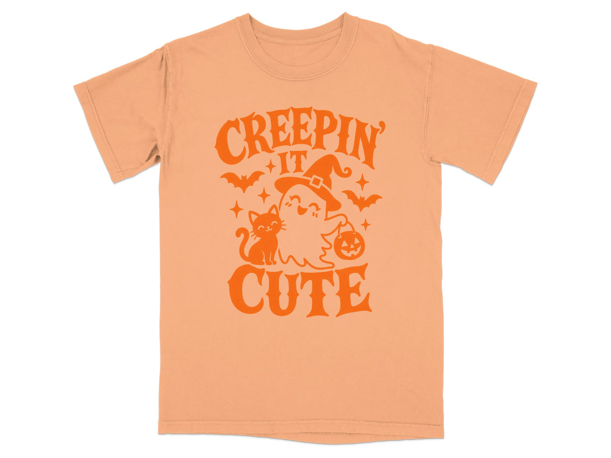 Peach t-shirt with orange Halloween graphic reading "Creepin' It Cute".