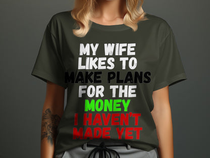 Dark green t-shirt with white, black, green, and red text saying "MY WIFE LIKES TO MAKE PLANS FOR THE MONEY I HAVEN'T MADE YET."