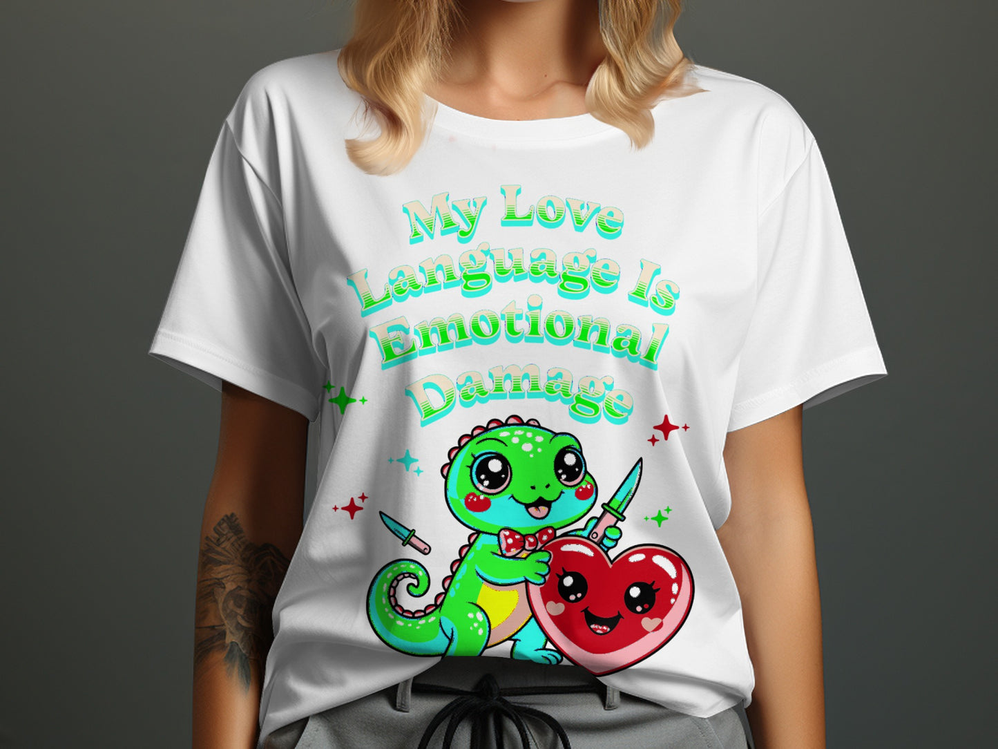 White t-shirt with cartoon dinosaur, heart, and knives, text says "My Love Language Is Emotional Damage".
