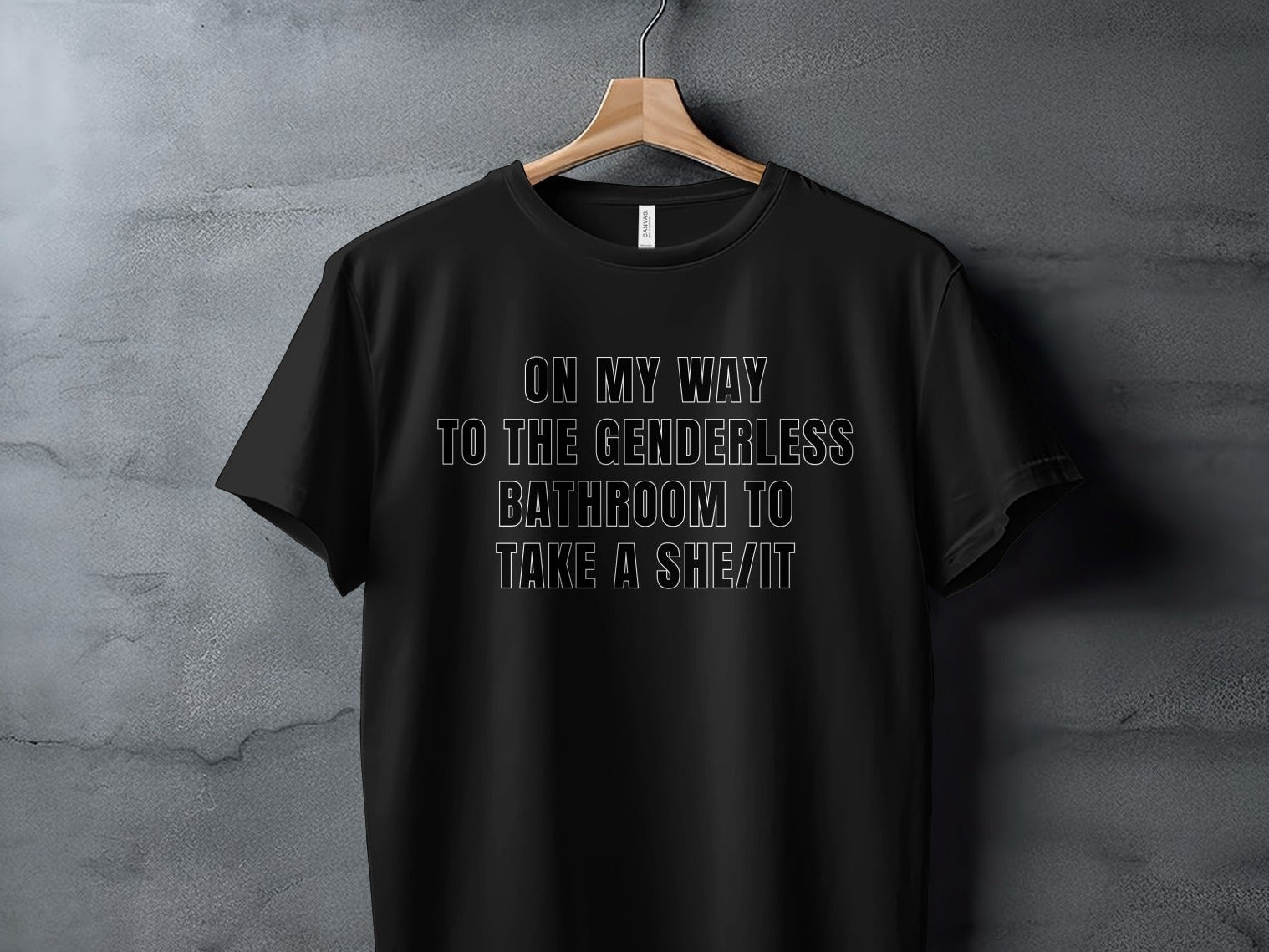 Black t-shirt with text "On my way to the genderless bathroom to take a she/it".