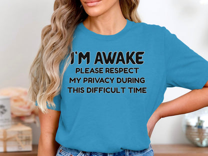 Blue t-shirt with black text saying "I'M AWAKE PLEASE RESPECT MY PRIVACY DURING THIS DIFFICULT TIME".