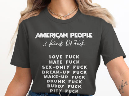 Dark gray t-shirt with white text: "AMERICAN PEOPLE 8 Kinds Of Fuck" followed by a list.