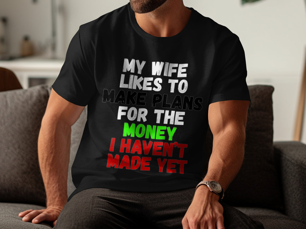 Black t-shirt with text "MY WIFE LIKES TO MAKE PLANS FOR THE MONEY I HAVEN'T MADE YET".