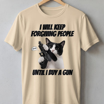 Cream t-shirt with a black and white cat holding a gun and text "I WILL KEEP FORGIVING PEOPLE UNTIL I BUY A GUN".