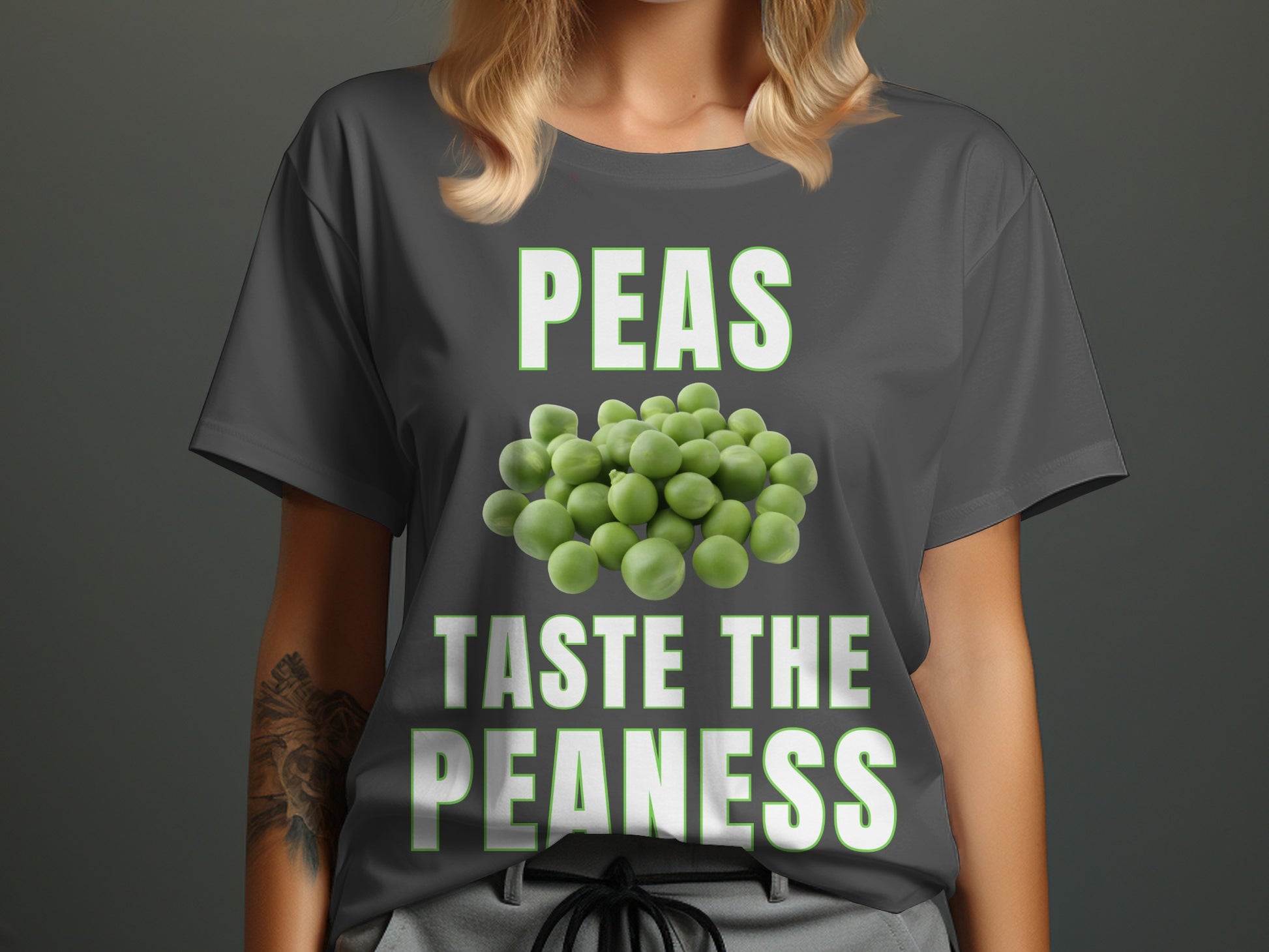 Dark grey t-shirt with white text "PEAS TASTE THE PEANESS" and pile of peas.