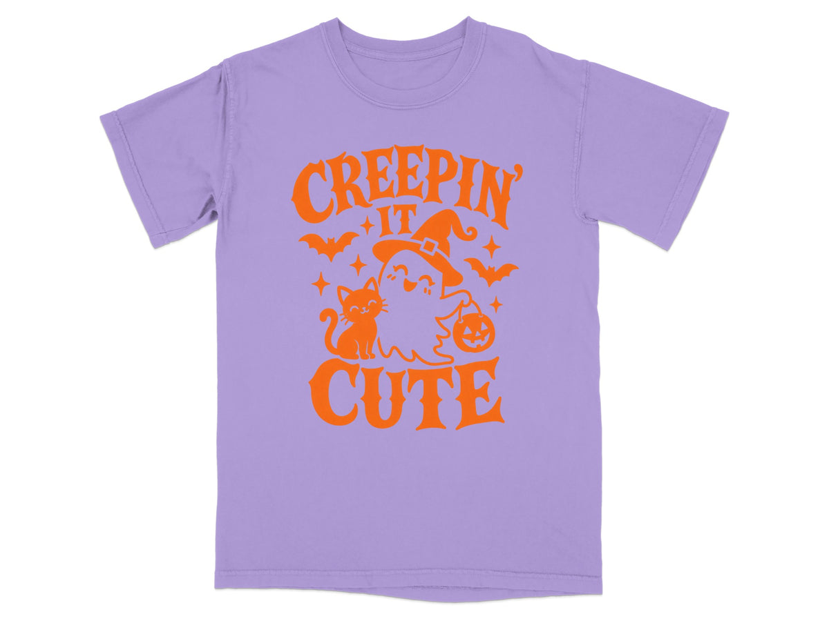 Purple t-shirt with orange "CREEPIN' IT CUTE" Halloween graphic featuring a ghost, cat, and bats.