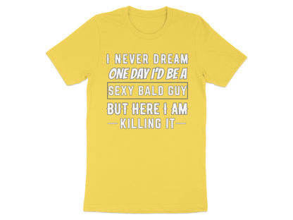 Yellow t-shirt with text: "I never dream one day I'd be a sexy bald guy but here I am - killing it-"