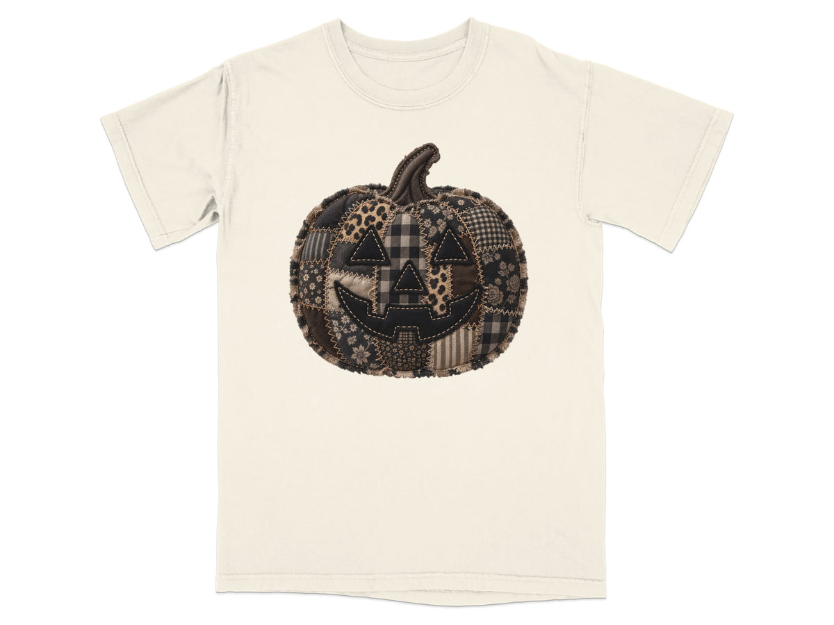 Cream t-shirt with a patchwork Halloween pumpkin graphic.