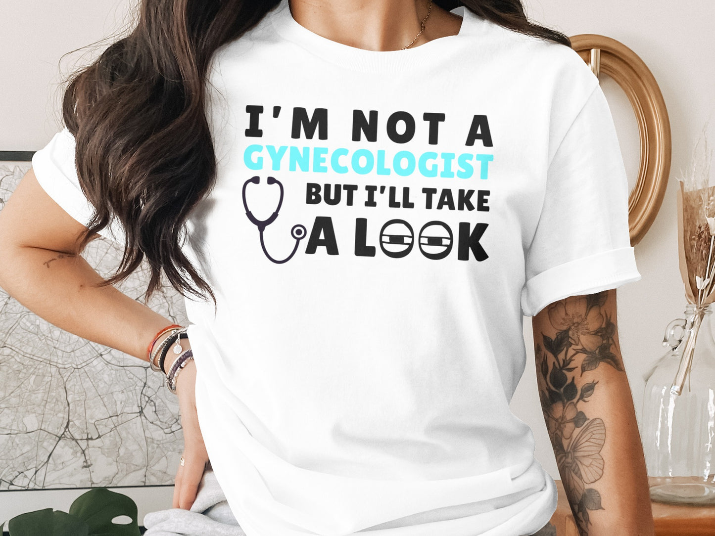 White t-shirt with graphic text: I'M NOT A GYNECOLOGIST BUT I'LL TAKE A LOOK