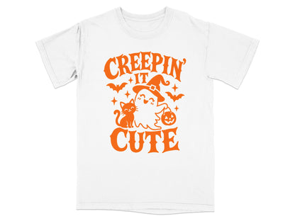 White t-shirt with orange "Creepin' It Cute" Halloween graphic featuring a ghost, cat, bats, and pumpkin.