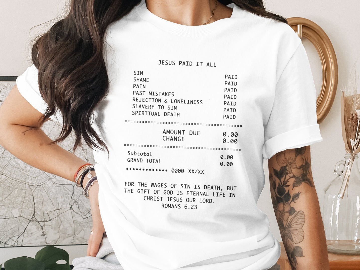 White t-shirt with "Jesus Paid It All" receipt graphic and Romans 6:23 scripture.