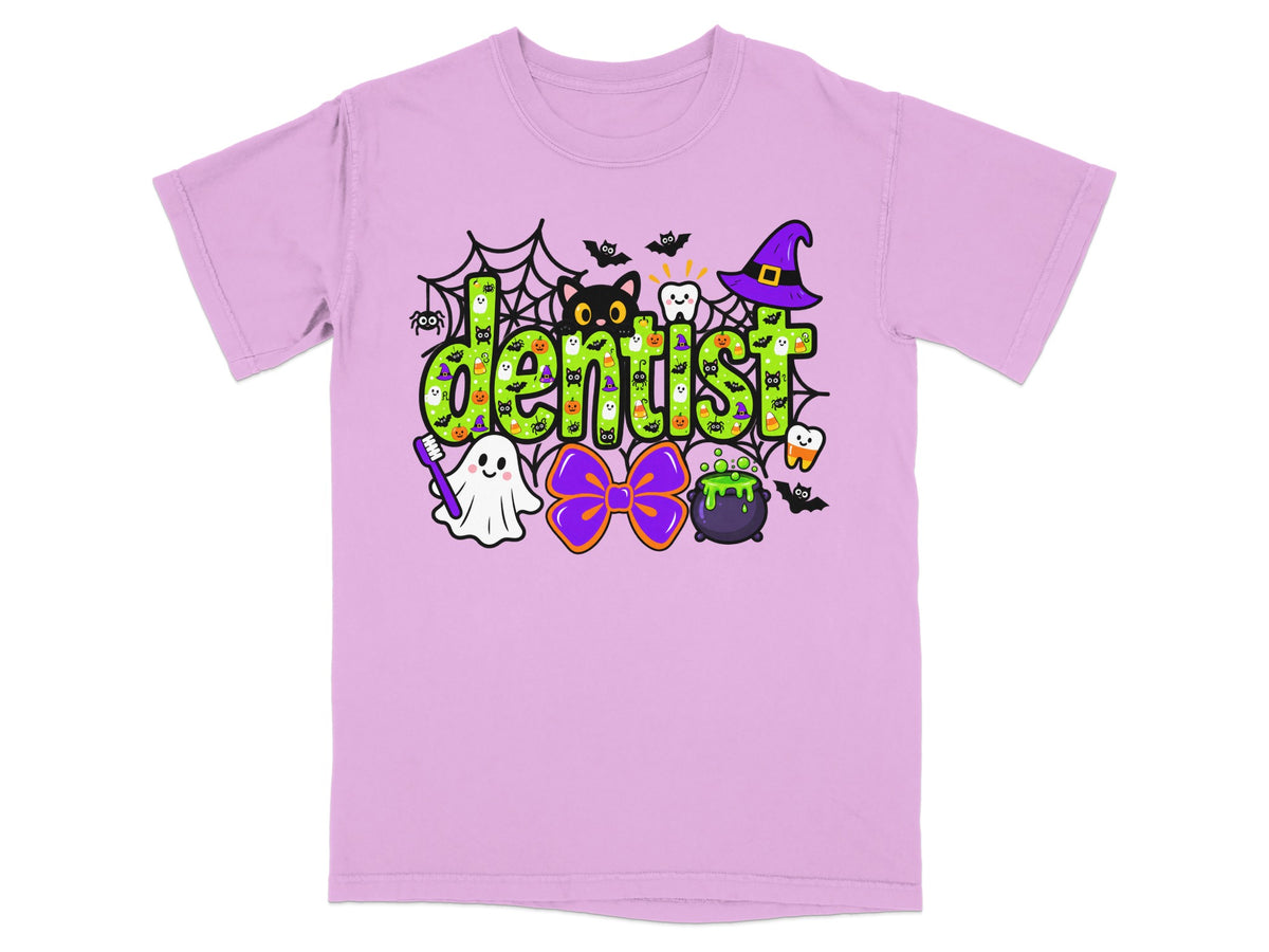 A light pink t-shirt with a green Halloween-themed graphic that reads "dentist" and includes various spooky icons.