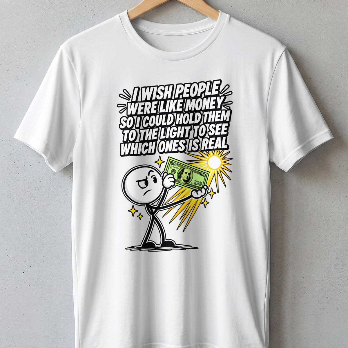 White t-shirt with cartoon man holding money and text: "I wish people were like money so I could hold them to the light to see which ones is real."