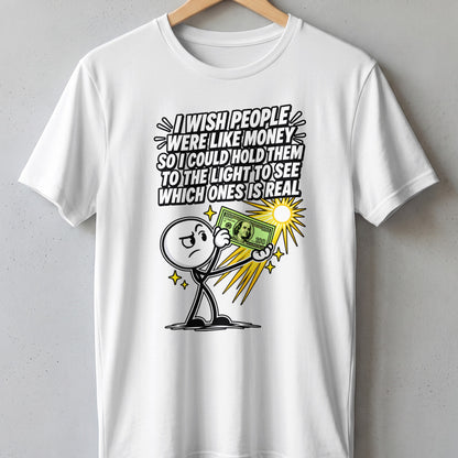 White t-shirt with cartoon man holding money and text: "I wish people were like money so I could hold them to the light to see which ones is real."