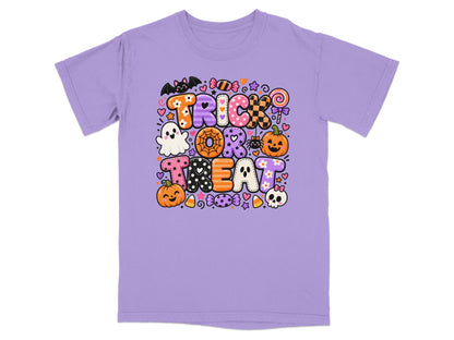 Purple t-shirt with "TRICK OR TREAT" in colorful Halloween-themed letters and icons.
