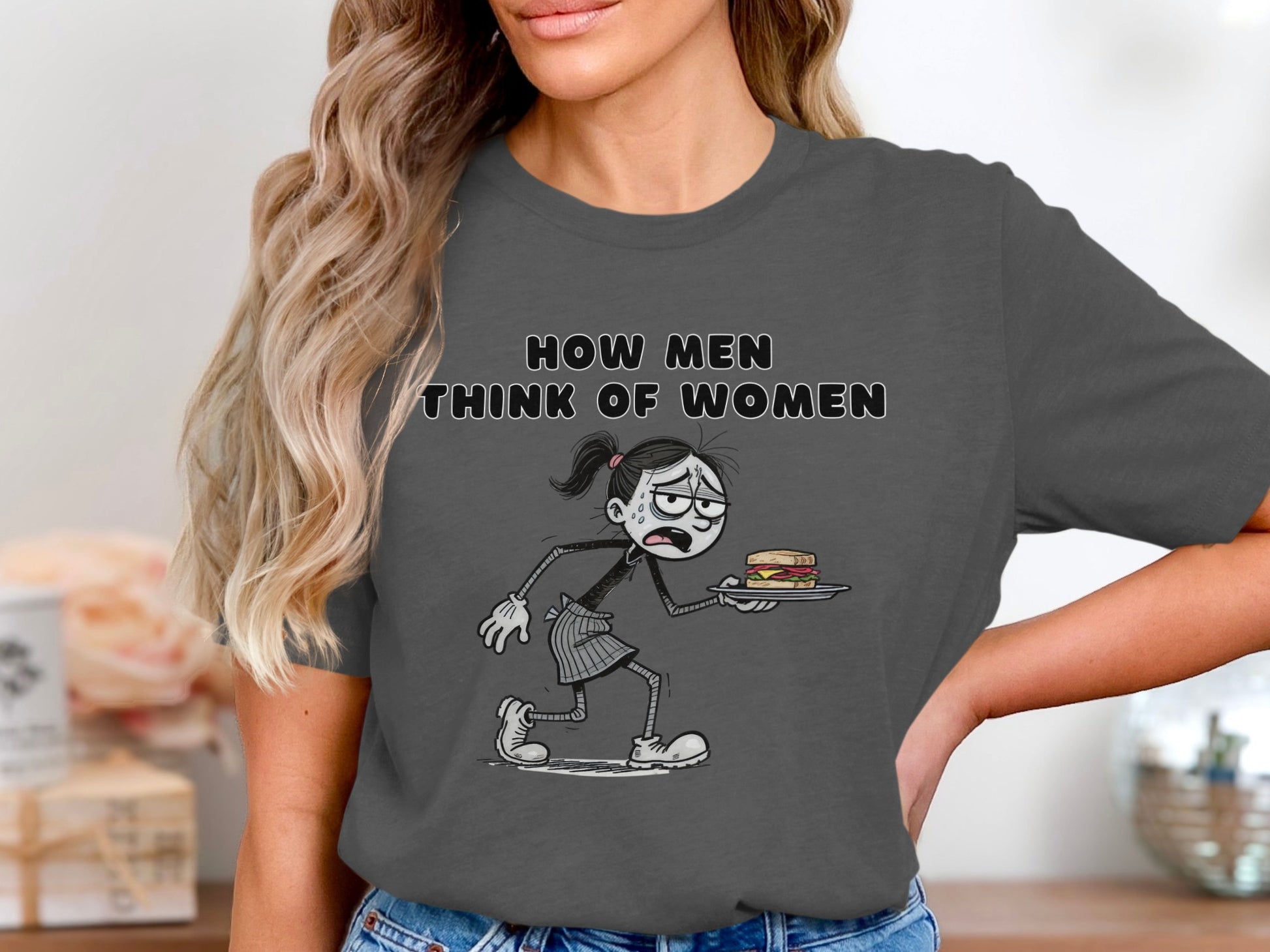 Dark gray t-shirt with "How men think of women" and cartoon of woman holding sandwich.