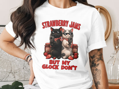 T-shirt graphic with two cats holding guns, strawberry jam, and text.