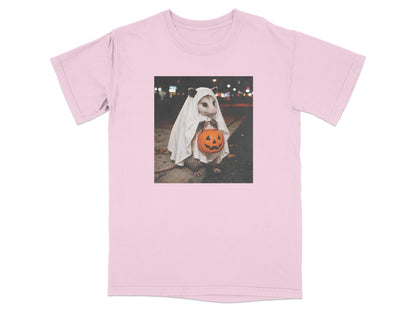 Opossum in ghost costume holding a jack-o'-lantern candy bucket on a street at night.