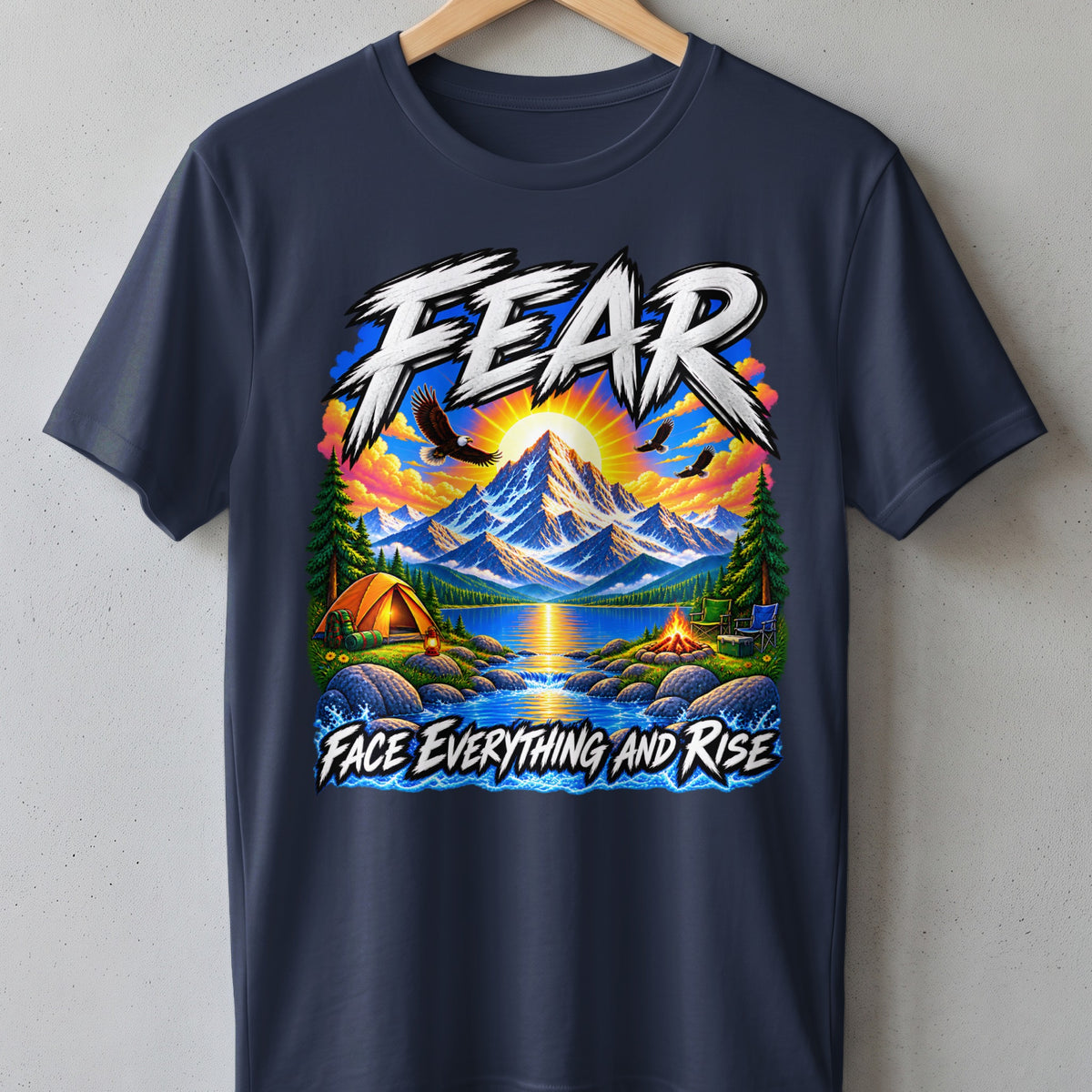 T-shirt graphic with mountains, lake, tent, campfire, and eagles. Text: "FEAR FACE EVERYTHING AND RISE."